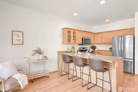 a view of a dining room with furniture a kitchen and chandelier