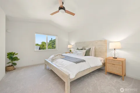 a bedroom with bed and a painting on the wall