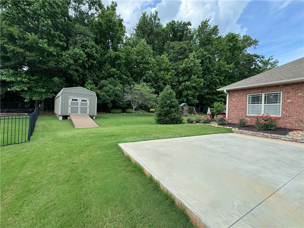 128 Baybrooke Lane Anderson, SC 29621 - Photo 37 of 37 An inviting backyard oasis offers a spacious patio, lush lawn, and handy storage shed.