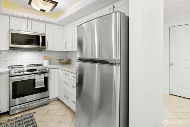 a kitchen with stainless steel appliances white cabinets and a stove top oven