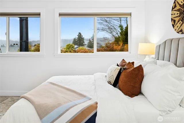 a bedroom with a bed and painting on the wall