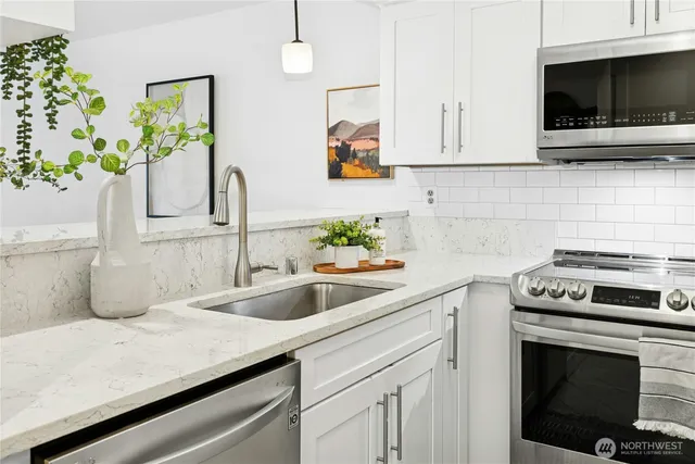 a kitchen with stainless steel appliances granite countertop a sink and a stove