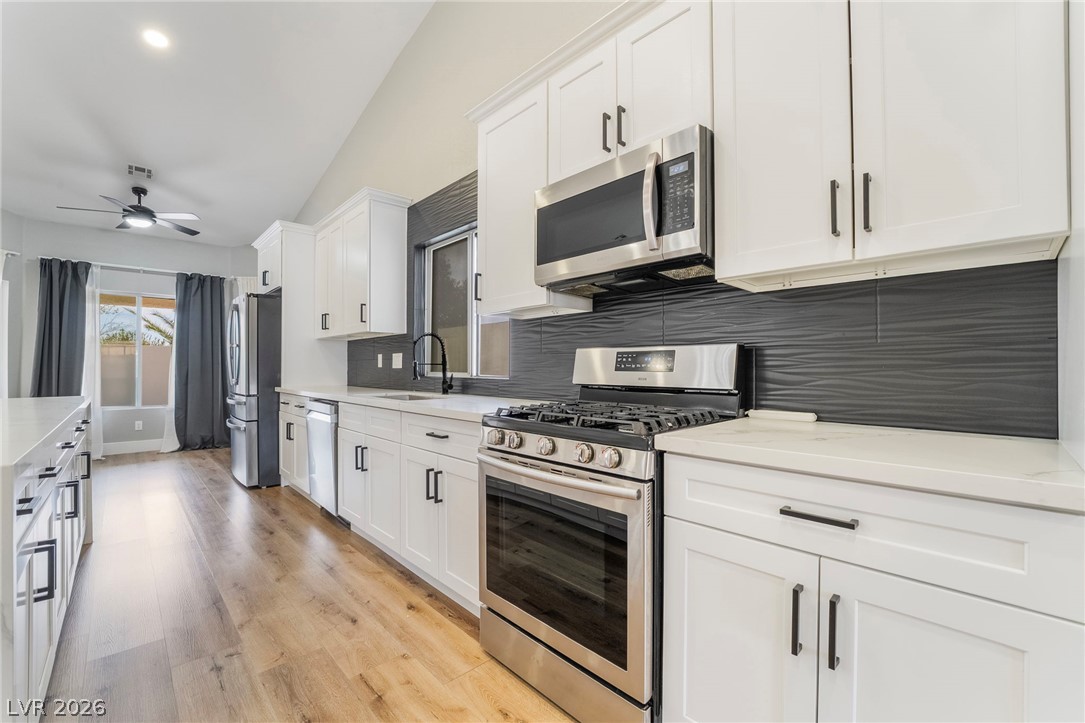 9171 West Viking Road Las Vegas, NV 89147 - Photo 19 of 43 Culinary creations come to life in this kitchen, featuring stainless steel appliances and vaulted ceilings.