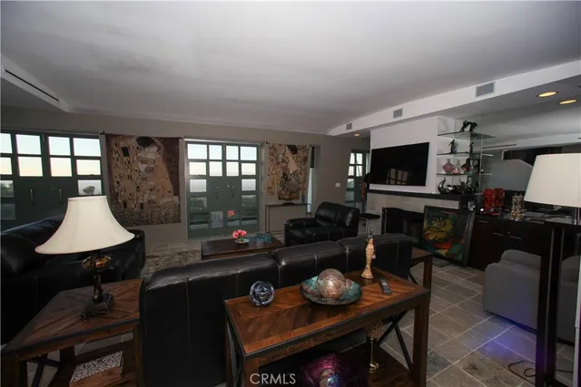 a living room with furniture a flat screen tv and a large window