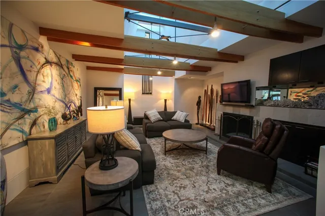 a living room with furniture a flat screen tv and kitchen view