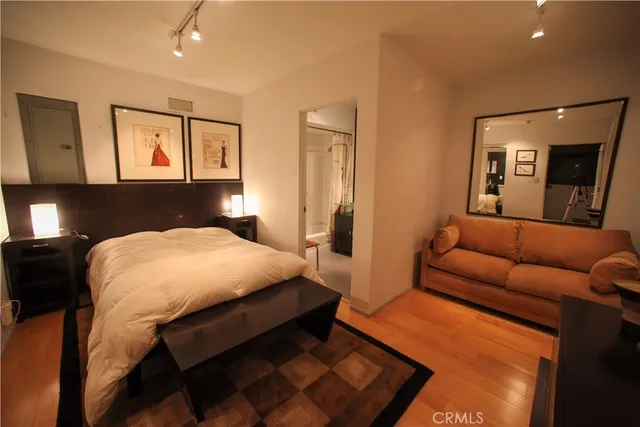 a bedroom with a bed and wooden floor