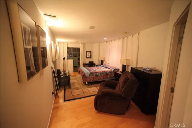 a walk in closet with wooden floor