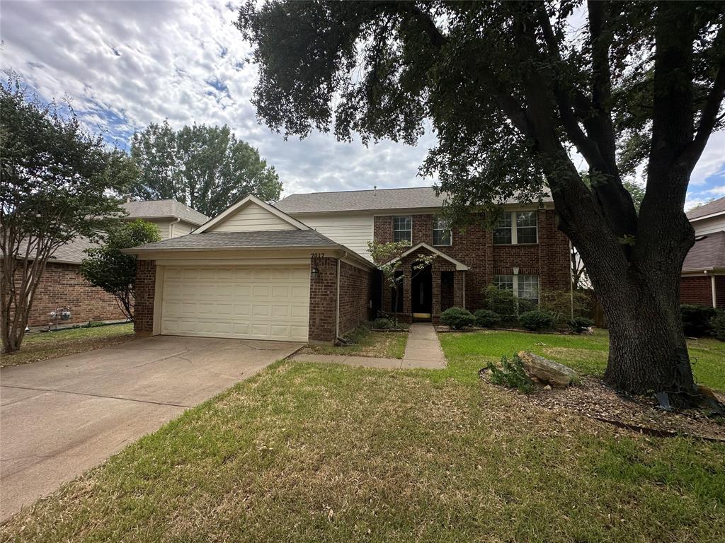 7517 Point Reyes Drive Fort Worth, TX 76137 - Photo 3 of 30 Two-story brick facade residence featuring a prominent mature tree, an attached garage, a concrete driveway, and a front walkway leading to the entry