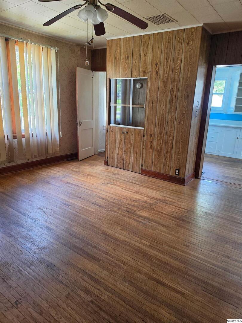 304 West 3rd Street Golden, IL 62339 - Photo 3 of 18 an empty room with wooden floor and windows