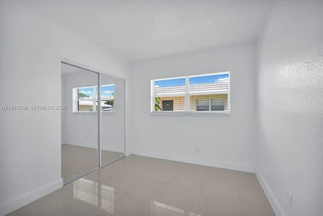 a view of an empty room with closet area