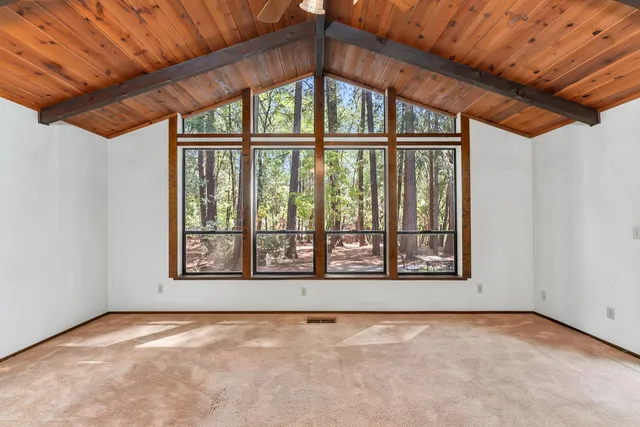 an empty room with chandelier fan