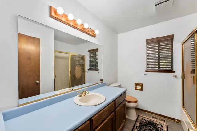 a view of a house with small yard plants and wooden fence