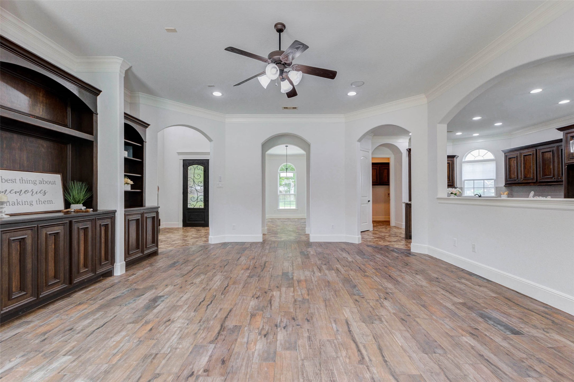 5327 Whitmore Fulshear, TX 77441 - Photo 13 of 50 This expansive family room showcases beautiful wood-look tile flooring, custom built-ins, and abundant space for both everyday living and special occasions.