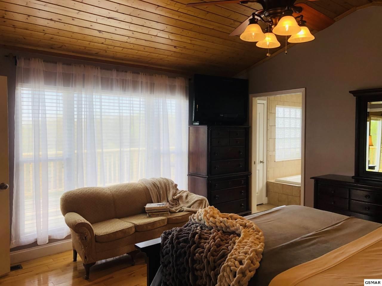 612 Chestnut Grove Road Dandridge, TN 37725 - Photo 14 of 16 a bedroom with a bed couch and a window