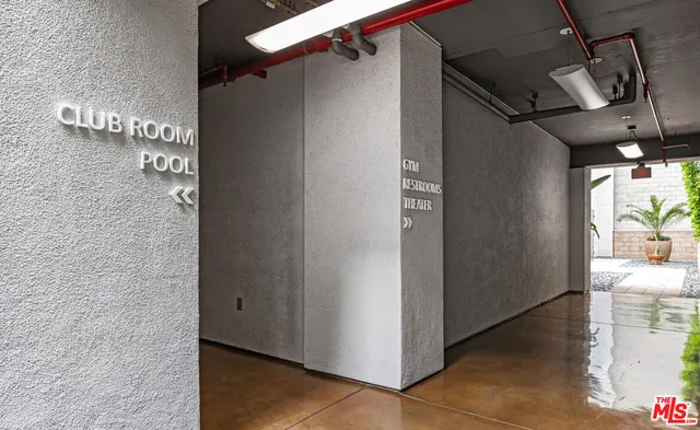 a kitchen with stainless steel appliances granite countertop a sink a stove top oven a chimney and living room view