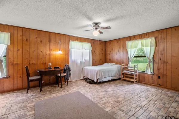 a bedroom with a bed table and chairs