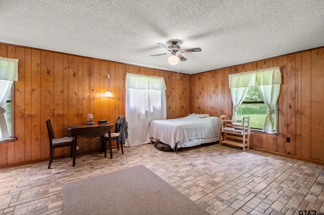 a bedroom with a bed table and chairs