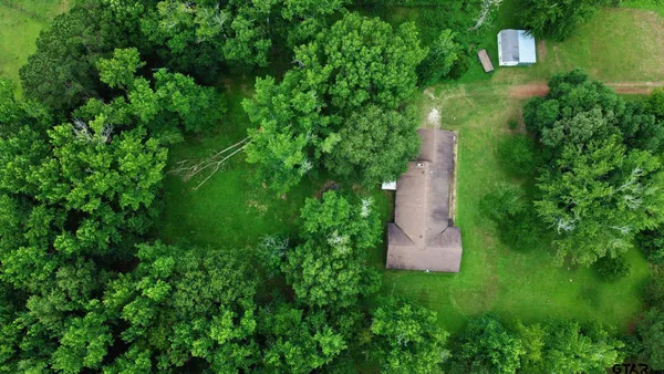 a view of a house with a yard and a forest
