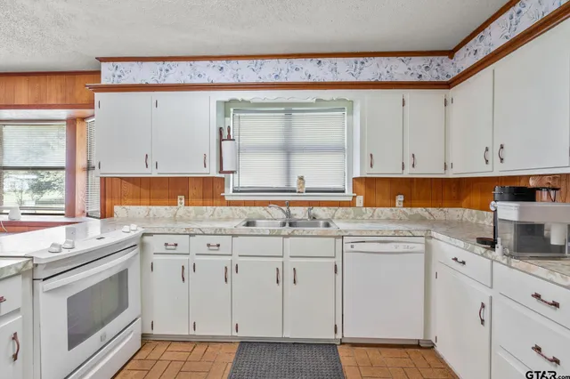 a kitchen with granite countertop white cabinets and white appliances