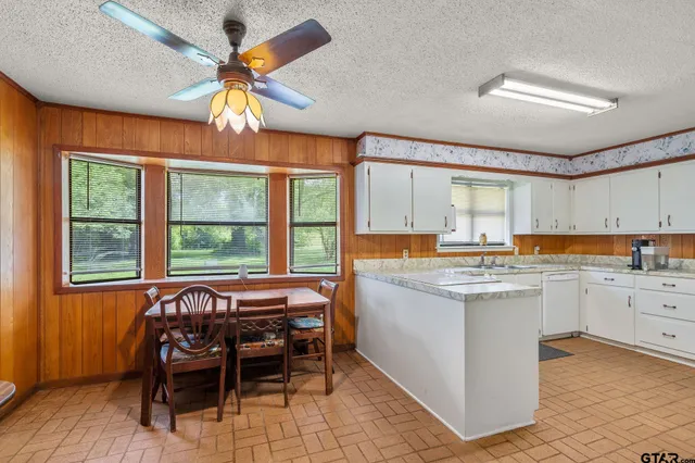 a kitchen with a dining table chairs sink and cabinets