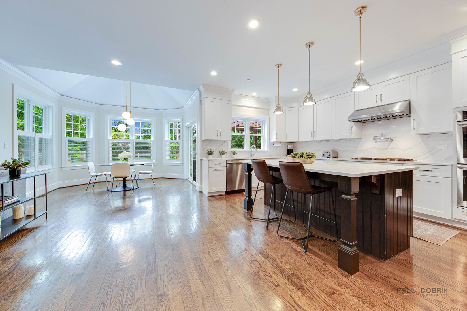 192 Gage Road Riverside, IL 60546 - Photo 11 of 56 a open dining room with stainless steel appliances granite countertop a stove a refrigerator a kitchen island a dining table and chairs with wooden floor