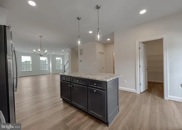 a view of a kitchen island a stove and wooden floor