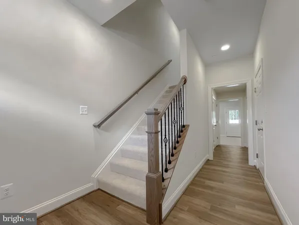 a view of a hallway with wooden floor and entryway