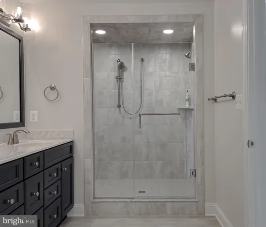 a bathroom with a shower sink vanity and mirror