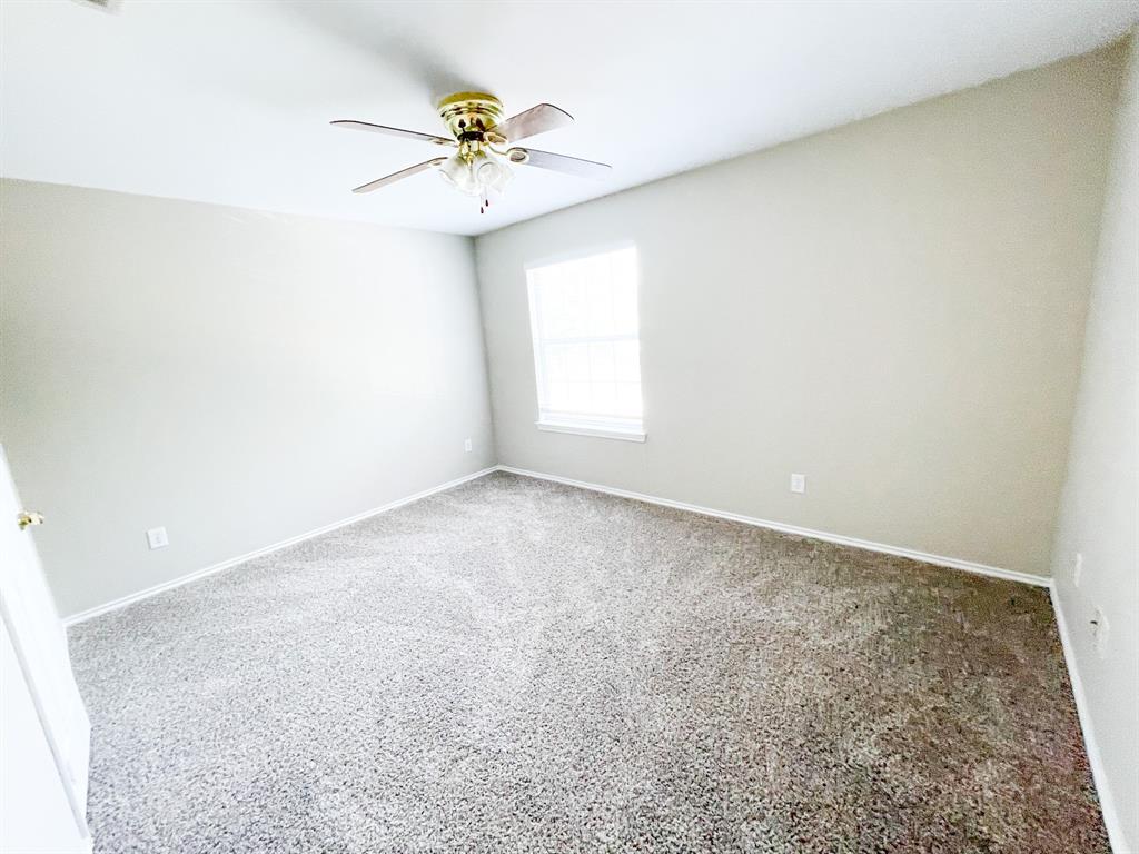 2704 Clemson Circle, Unit A Rowlett, TX 75088 - Photo 13 of 13 an empty room with a chandelier fan and windows