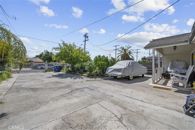 a view of a patio with table and chairs under an umbrella next to a road