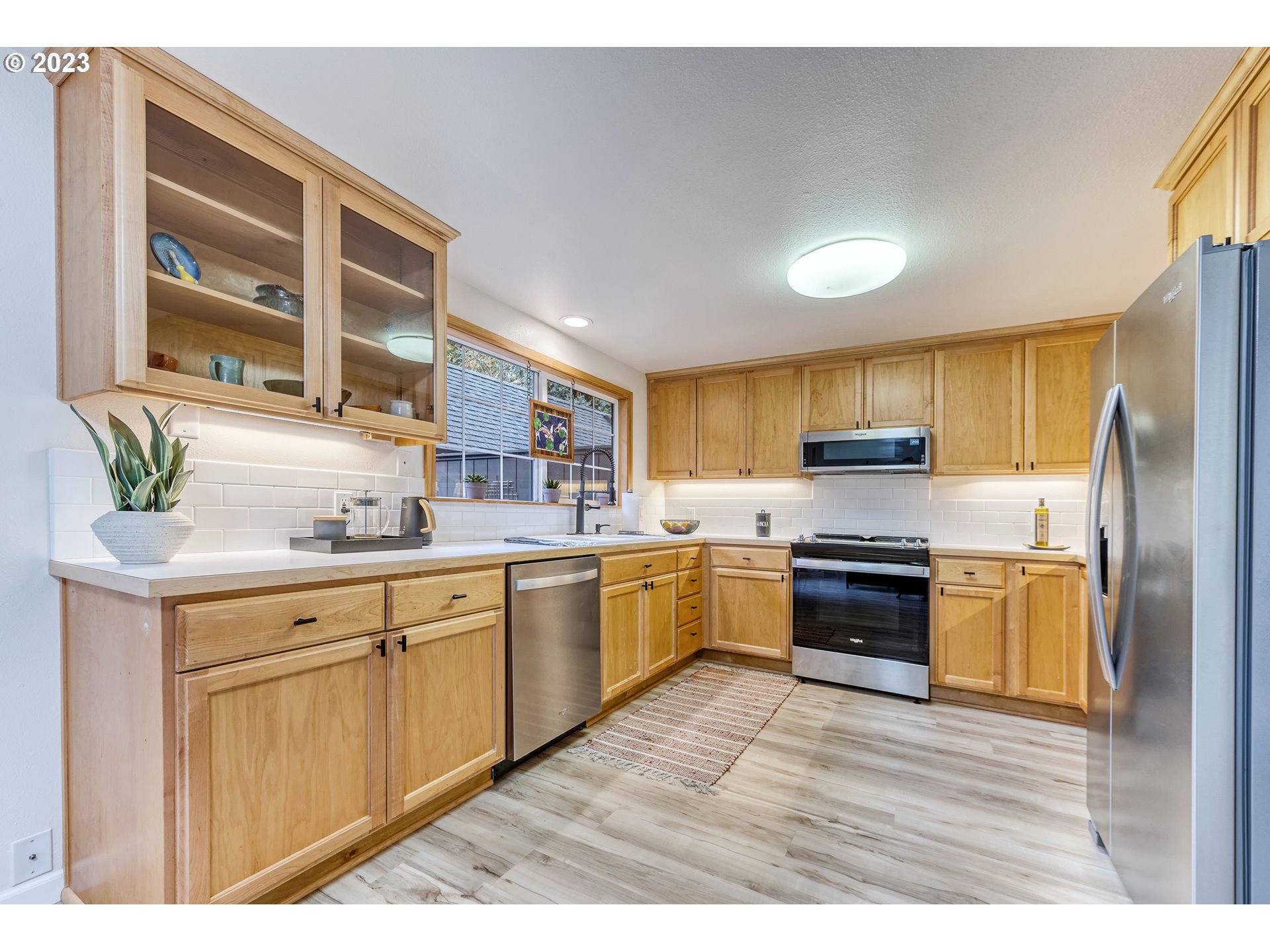 109 Westbrook Way Eugene, OR 97405 - Photo 9 of 36 a kitchen with stainless steel appliances granite countertop a stove a sink dishwasher a refrigerator and a microwave oven with wooden floor