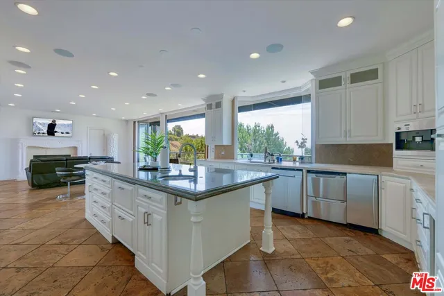 a kitchen with granite countertop a sink stainless steel appliances a counter space and cabinets