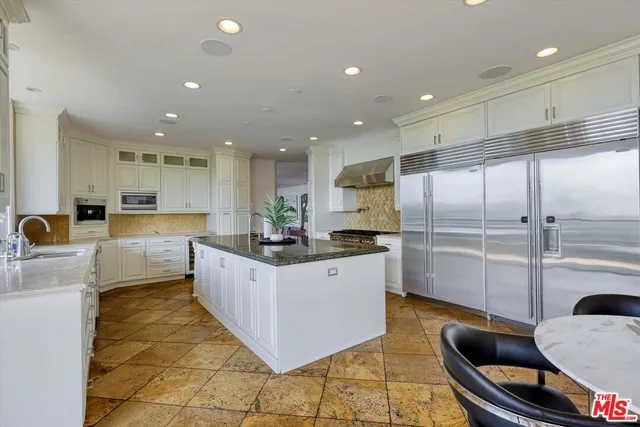 a kitchen with granite countertop a sink a window stainless steel appliances and cabinets