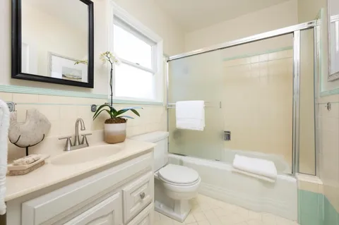 a bathroom with a granite countertop sink a toilet and shower