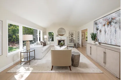 a living room with furniture a large window and a fireplace