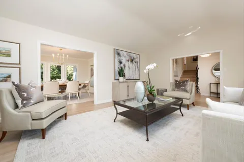 a living room with furniture and a large mirror with wooden floor