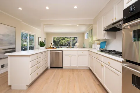 a kitchen with white cabinets and white appliances