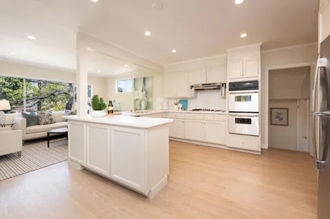 a kitchen with white cabinets and white appliances