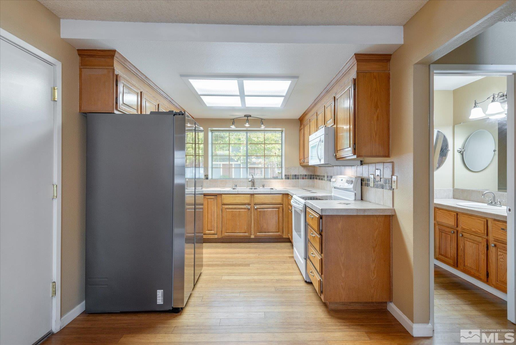 1910 Tuolumne Drive Reno, NV 89523 - Photo 11 of 36 a large kitchen with stainless steel appliances granite countertop a refrigerator a sink dishwasher a oven with wooden cabinets and wooden floor