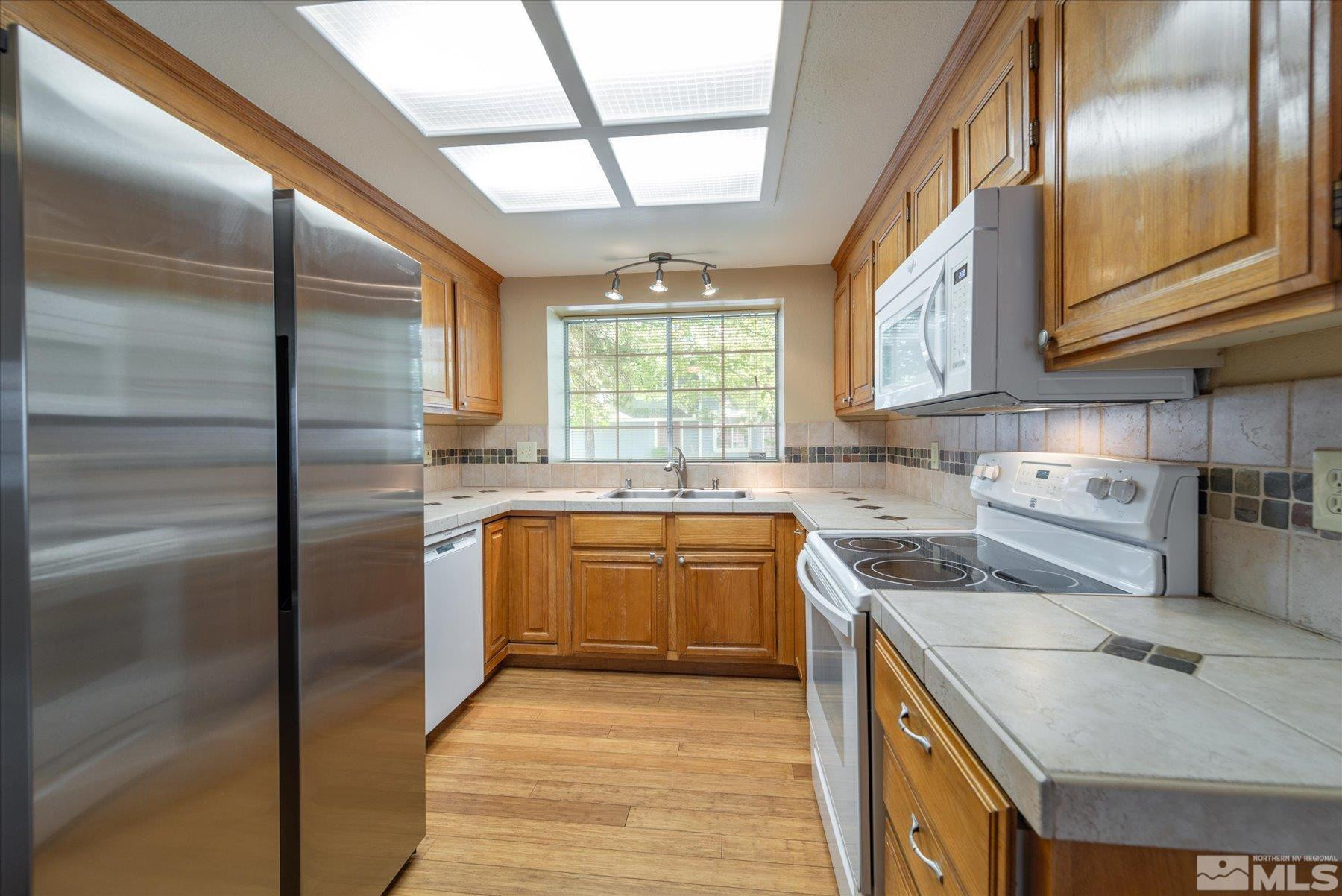 1910 Tuolumne Drive Reno, NV 89523 - Photo 12 of 36 a kitchen with stainless steel appliances granite countertop a sink a stove and a refrigerator