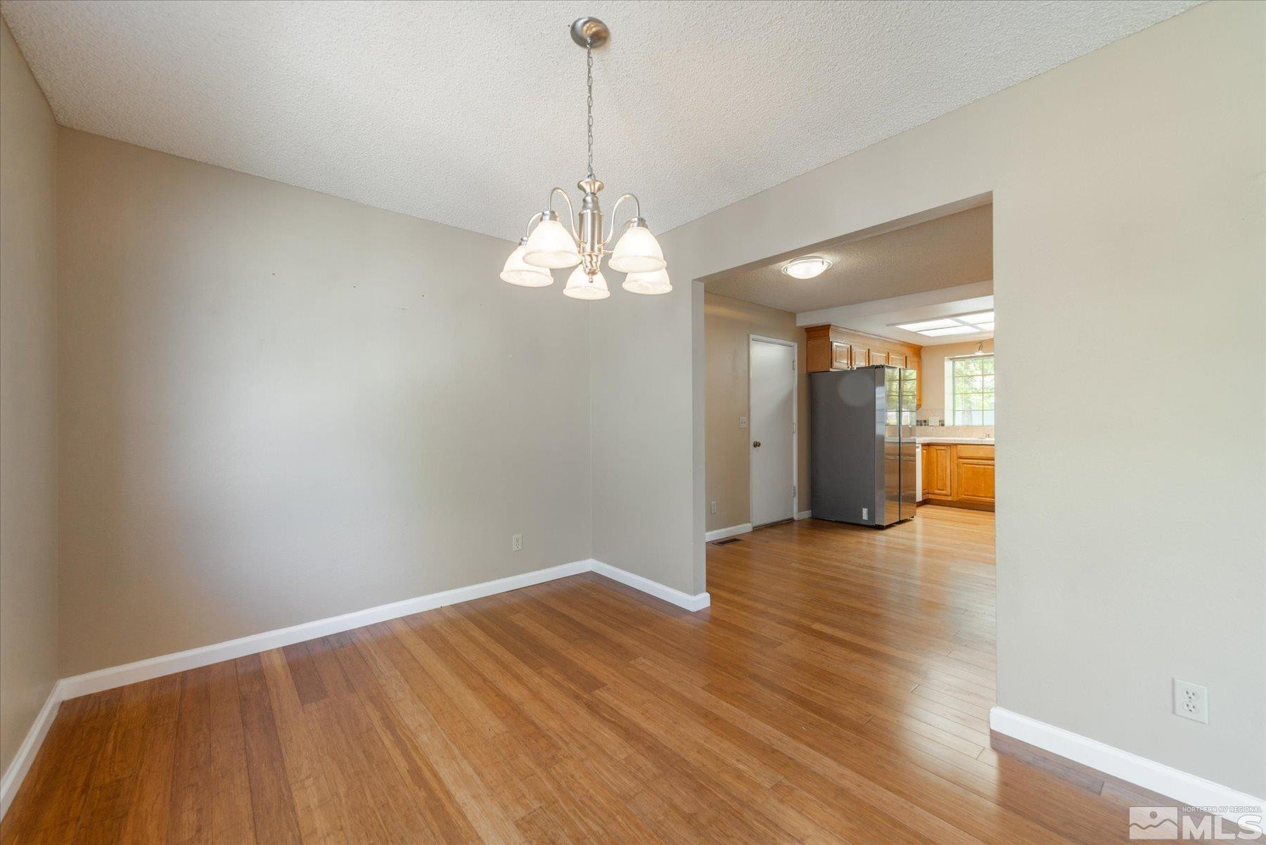 1910 Tuolumne Drive Reno, NV 89523 - Photo 17 of 36 a view of empty room with wooden floor and kitchen