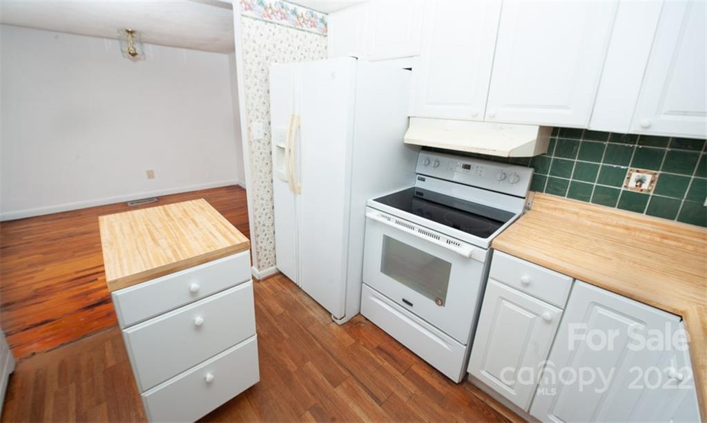 105 Smith Graveyard Road Asheville, NC 28806 - Photo 8 of 16 a kitchen with white cabinets and white appliances