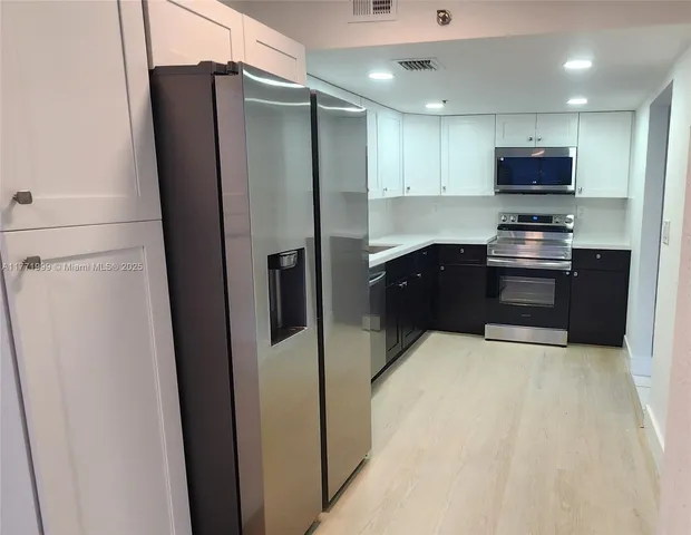 a kitchen with stainless steel appliances granite countertop a refrigerator and a stove