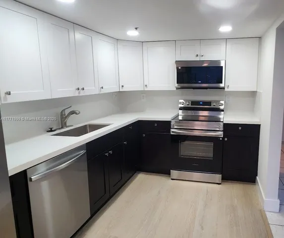 a kitchen with stainless steel appliances granite countertop a sink and a stove