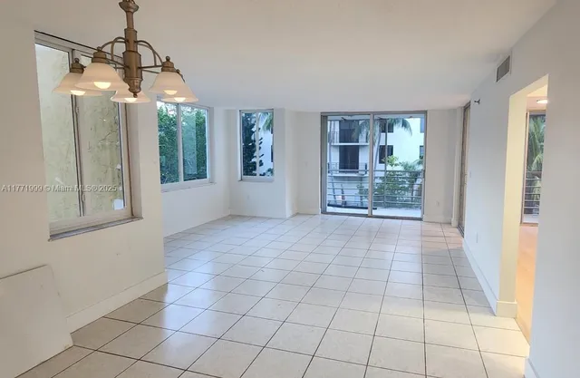 a view of an empty room with glass door and a window