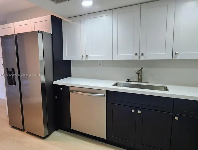 a kitchen with stainless steel appliances a refrigerator sink and cabinets