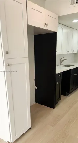 a view of kitchen with refrigerator and cabinets