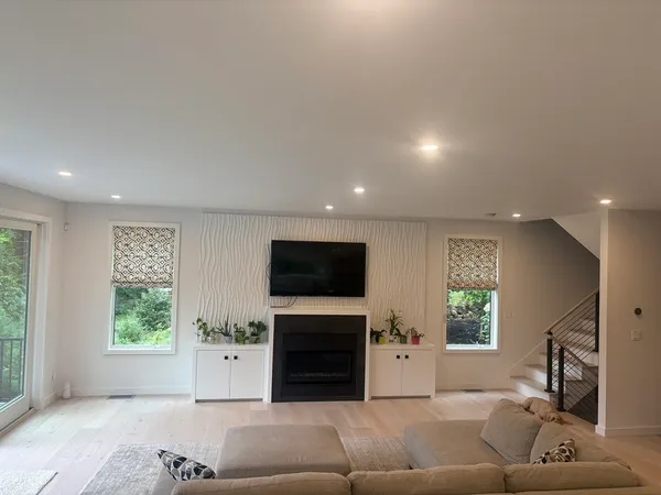 a living room with furniture a window and a flat screen tv