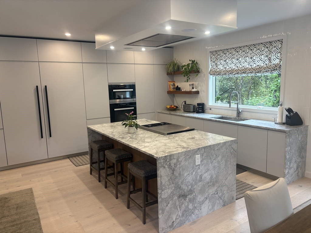 416 Conant Road Weston, MA 02493 - Photo 9 of 15 a kitchen with kitchen island a counter top space a sink stainless steel appliances and cabinets