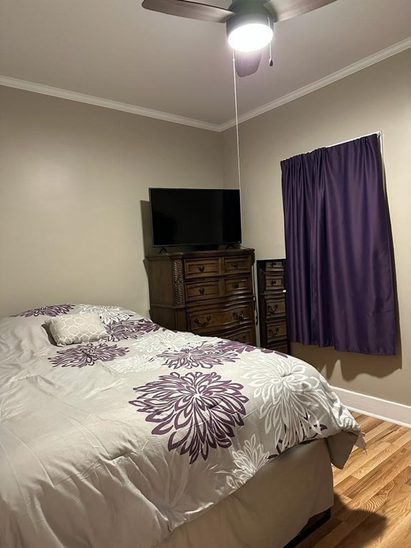 681 Millbury Street Worcester, MA 01607 - Photo 11 of 18 a bed sitting in a bedroom and a flat tv screen on dresser